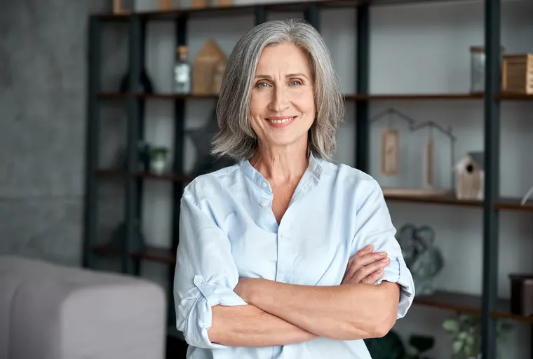 A confident mature woman smiling, the kind of restored function and appearance that restorative dentistry provides, at Copper Sky Dental in Peoria, AZ