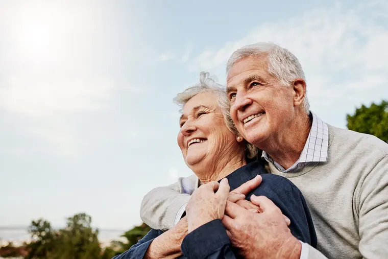 A senior couple smiling together outdoors, the kind of established Sun City West residents Copper Sky Dental cares for