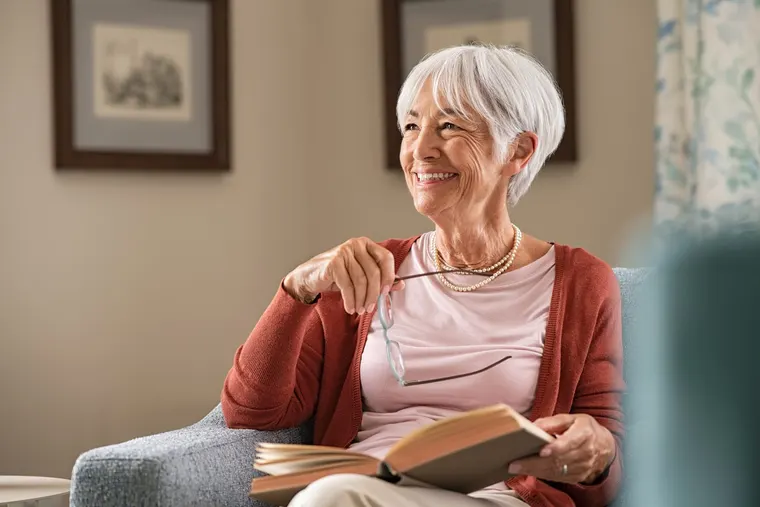 A relaxed senior woman reading comfortably at home, the kind of easy recovery a gentle tooth extraction allows, at Copper Sky Dental in Peoria, AZ